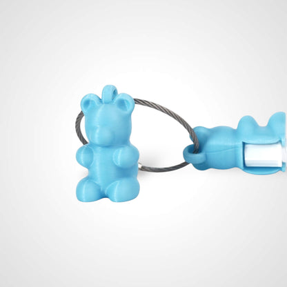 Two teal polylactic acid created using additive manufacturing gummy bear clips on steel cable keyring. Featured attached to a syringe. Shown on a white background.