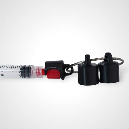 Black polylactic acid created using additive manufacturing B-Braun cap clip on steel cable keyring. Featured attached to a syringe. Shown on white background.