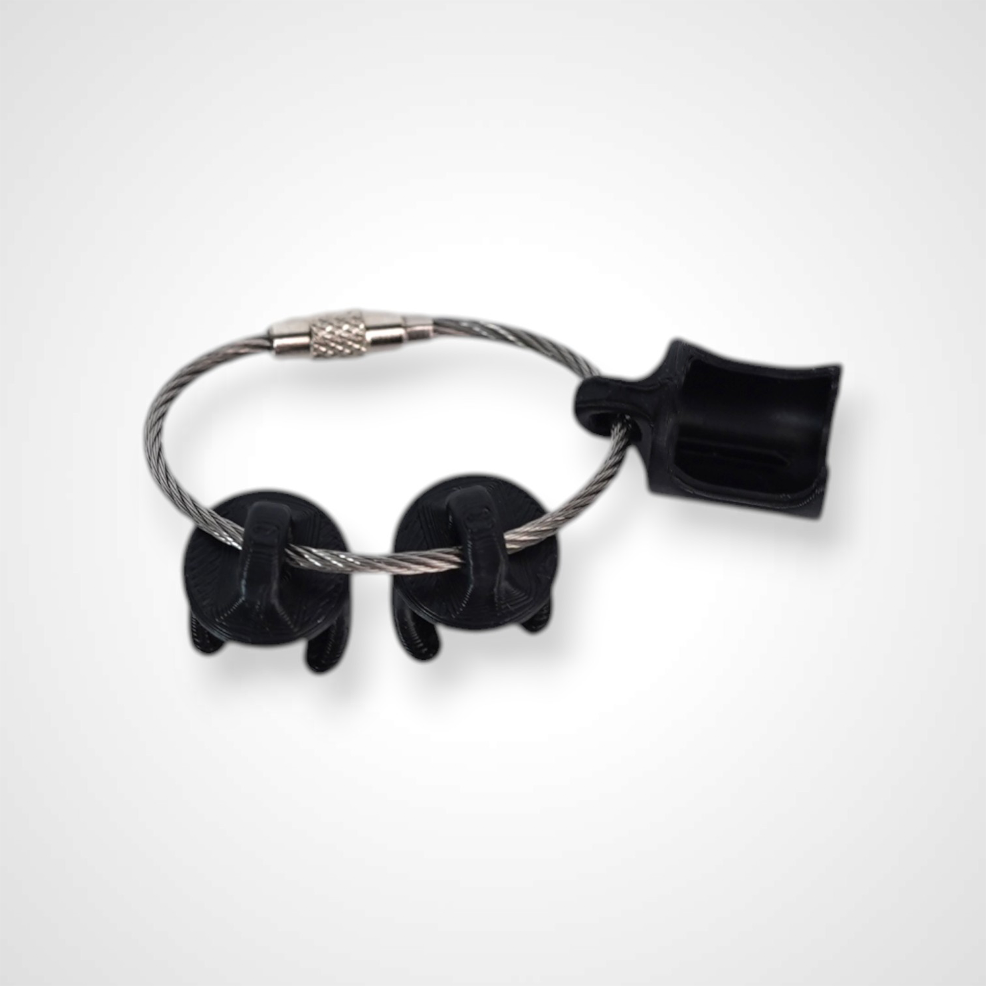 Three black polylactic acid created using additive manufacturing classic cap clips on steel cable keyring. Shown on a white background.