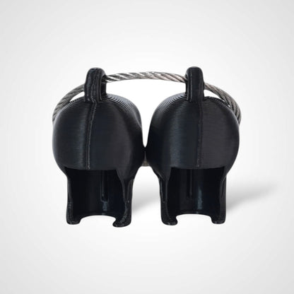 Two black polylactic acid created using additive manufacturing skull cap clips on steel cable keyring. Shown on a white background.