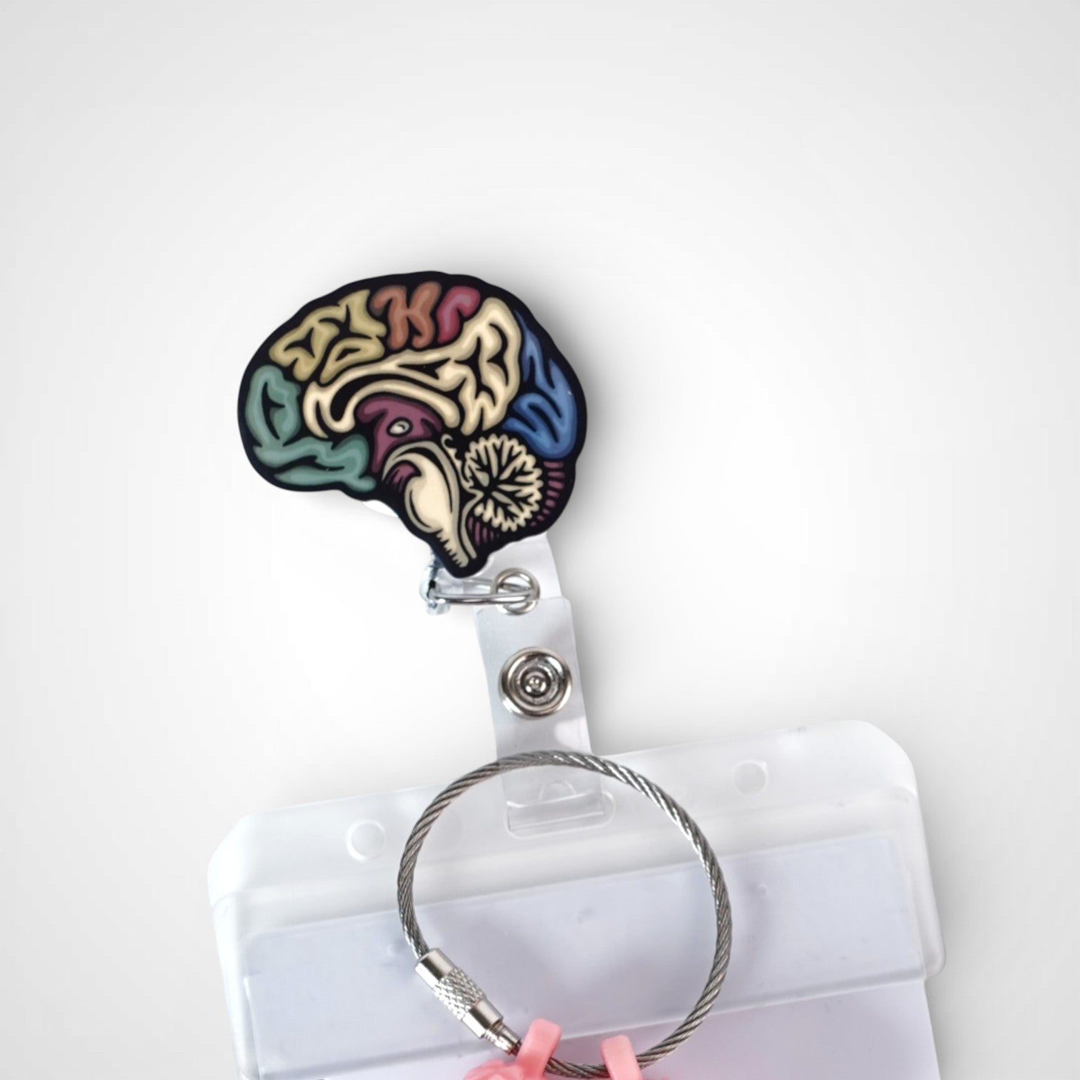 Sagittal Brain badge reel. On a swivel-alligator clip that rotates 360° with a nylon retractable string. Shown on a white background.
