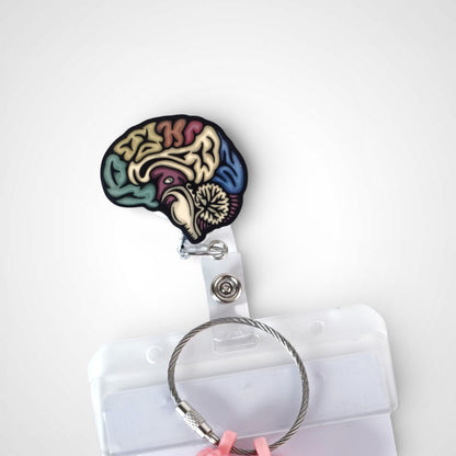 Sagittal Brain badge reel. On a swivel-alligator clip that rotates 360° with a nylon retractable string. Shown on a white background.