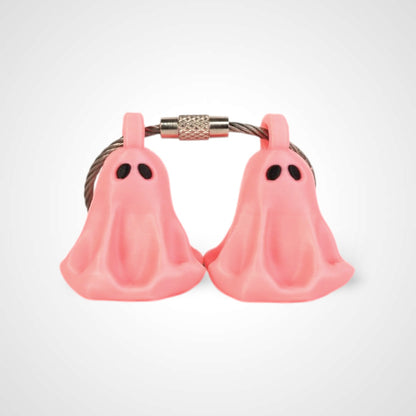 Two pink polylactic acid created using additive manufacturing ghost cap clips on steel cable keyring. Shown on a white background.