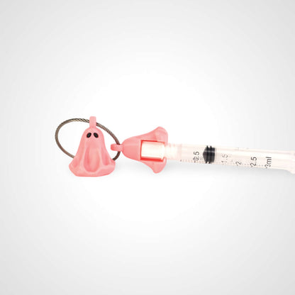 Two pink polylactic acid created using additive manufacturing ghost cap clips on steel cable keyring. Featured attached to a syringe. Shown on a white background.