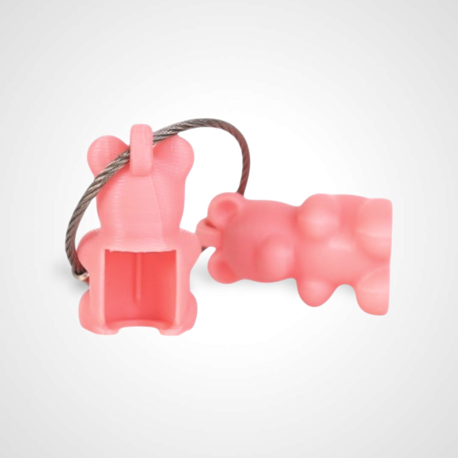Two pink polylactic acid created using additive manufacturing gummy bear cap clips on steel cable keyring. Shown on a white background.