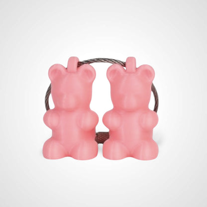Two pink polylactic acid created using additive manufacturing gummy bear cap clips on steel cable keyring. Shown on a white background.