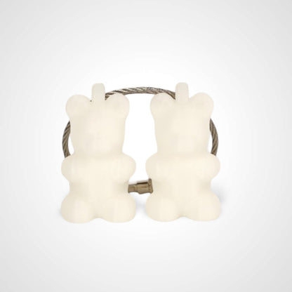 Two white polylactic acid created using additive manufacturing gummy bear cap clips on steel cable keyring. Shown on a white background.