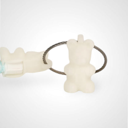 Two white polylactic acid created using additive manufacturing gummy bear cap clips on steel cable keyring. Featured attached to a syringe. Shown on a white background.