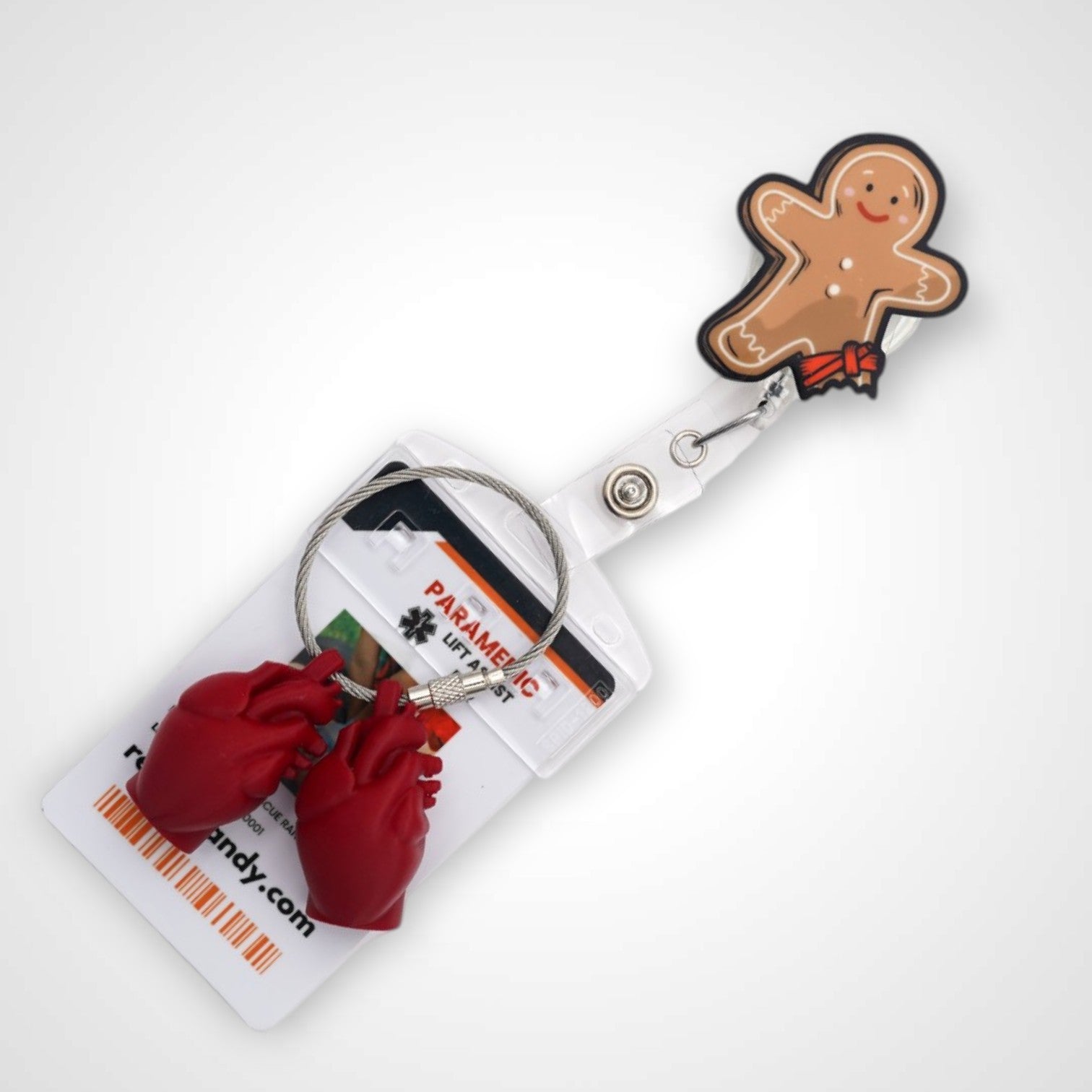 Tourniquet gingerbread man badge reel. On a swivel-alligator clip that rotates 360° with a nylon retractable string. Shown on a white background. 