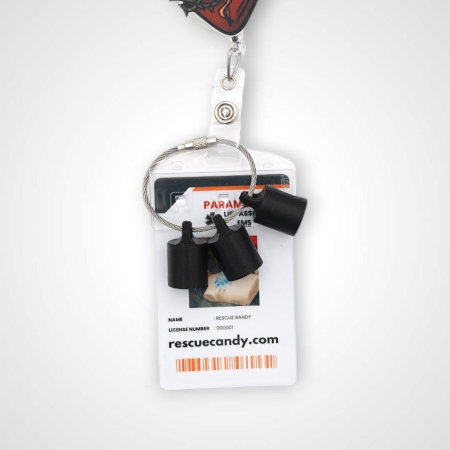 Three black polylactic acid created using additive manufacturing classic cap clips on steel cable keyring. Featured attached to a badge. Shown on a white background.