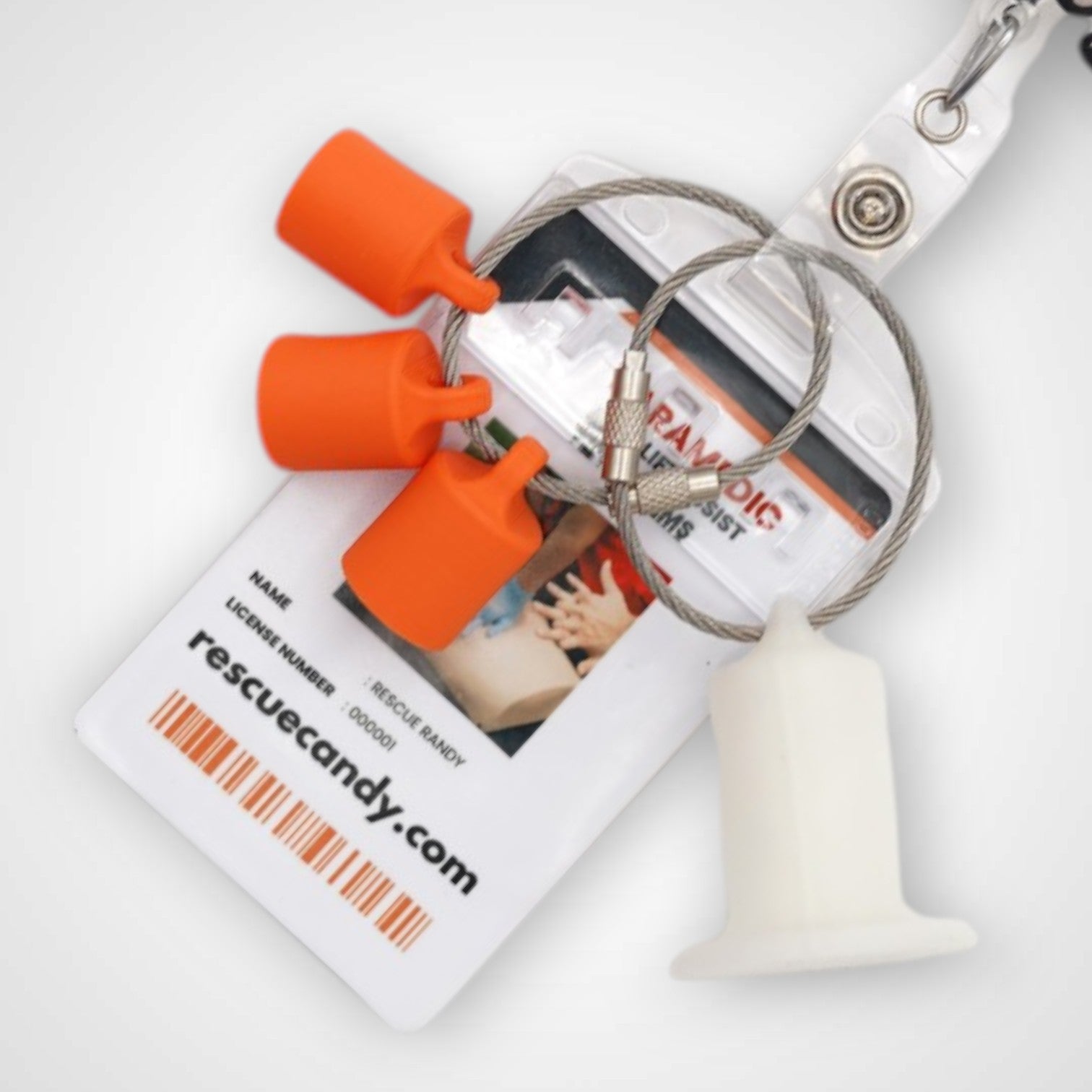Three orange polylactic acid created using additive manufacturing classic cap clips on steel cable keyring. Featured attached to a badge. Shown on a white background.