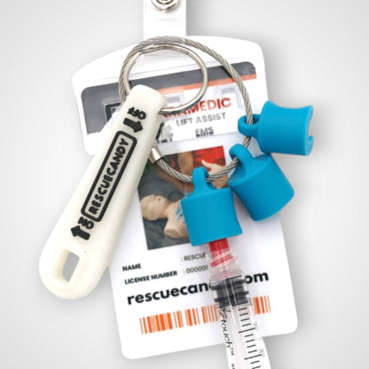 Blue polylactic acid created using additive manufacturing B-Braun cap clip on steel cable keyring. Featured attached to a syringe and on a badge. Shown on white background.