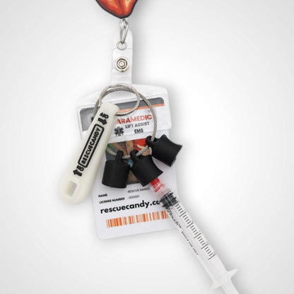 Black polylactic acid created using additive manufacturing B-Braun cap clip on steel cable keyring. Featured attached to a syringe and on a badge. Shown on white background.