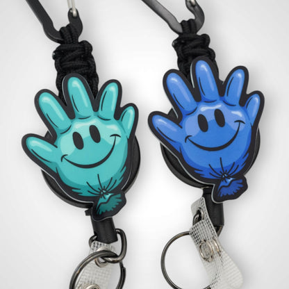 Teal and blue happy glove partner set badge reel. On a carabiner with a steel retractable cable. Shown on a white background.