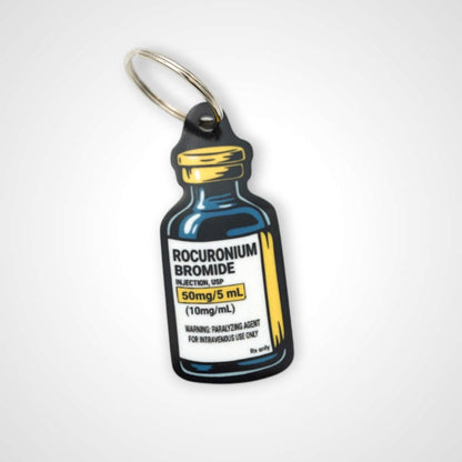 Rocuronium vial cast acrylic keychain with double coil keyring. Shown on white background.