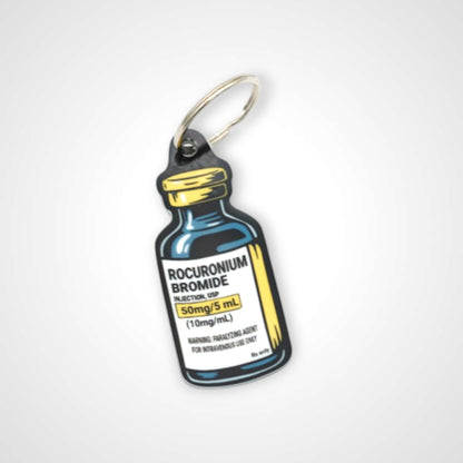 Rocuronium vial cast acrylic keychain with double coil keyring. Shown on white background.