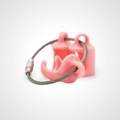 Three pink polylactic acid created using additive manufacturing classic cap clips on steel cable keyring. Shown on a white background.