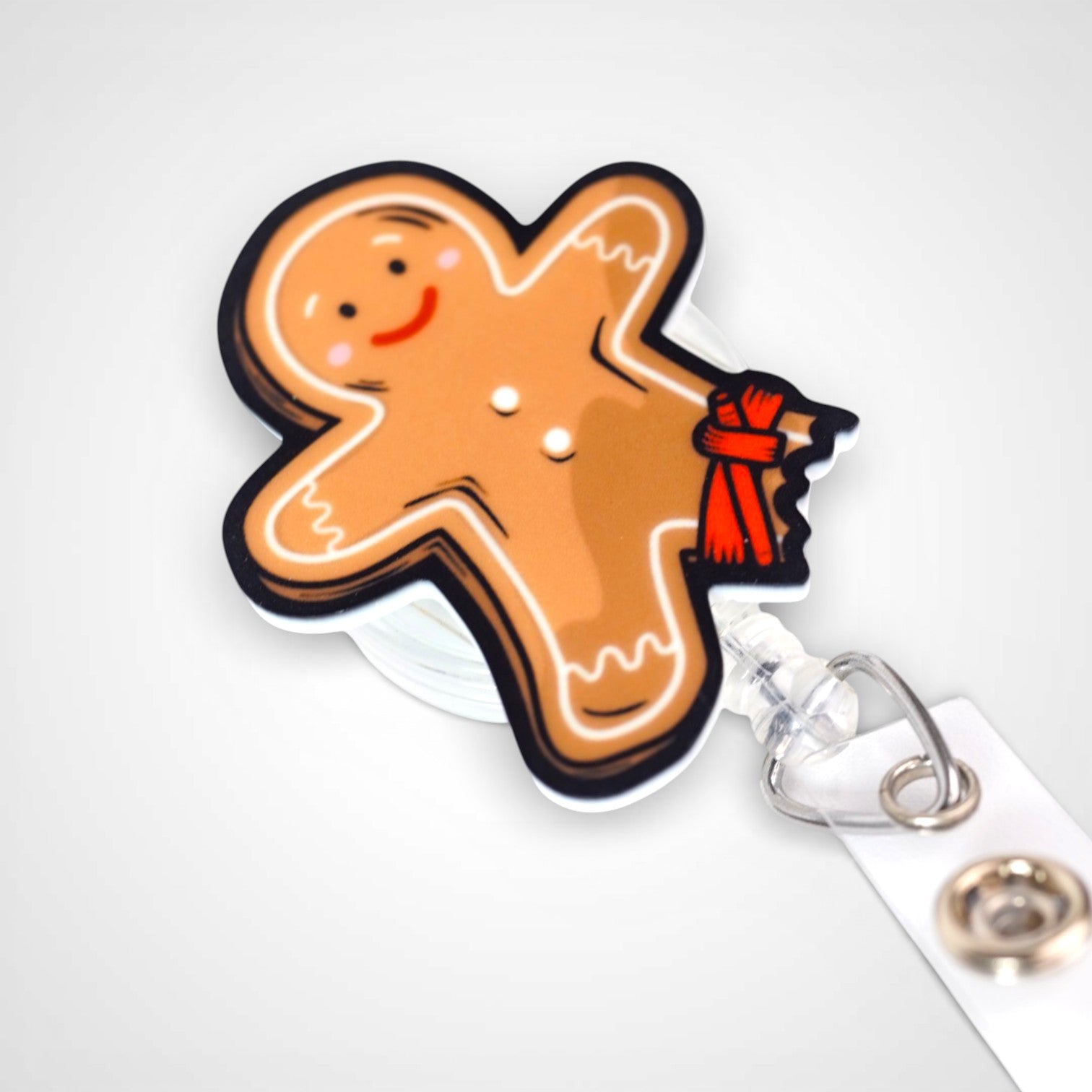 Tourniquet gingerbread man badge reel. On a swivel-alligator clip that rotates 360° with a nylon retractable string. Shown on a white background.