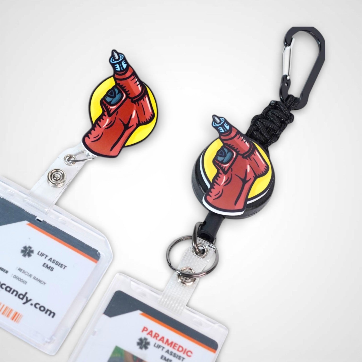 IO Drill badge reel. On a swivel-alligator clip that rotates 360° with a nylon retractable string next to a carabiner with a steel retractable cable.Shown on a white background.