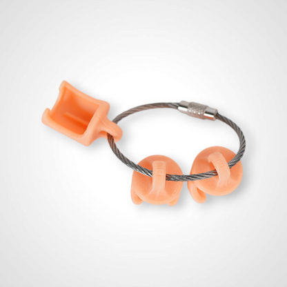 Three orange polylactic acid created using additive manufacturing classic cap clips on steel cable keyring. Shown on a white background.