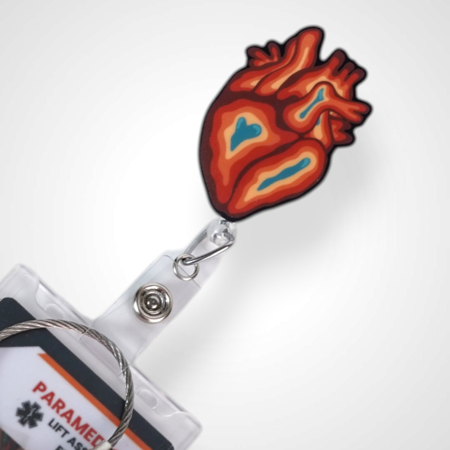 Trippy heart badge reel. On a swivel-alligator clip that rotates 360° with a nylon retractable string. Shown on a white background.