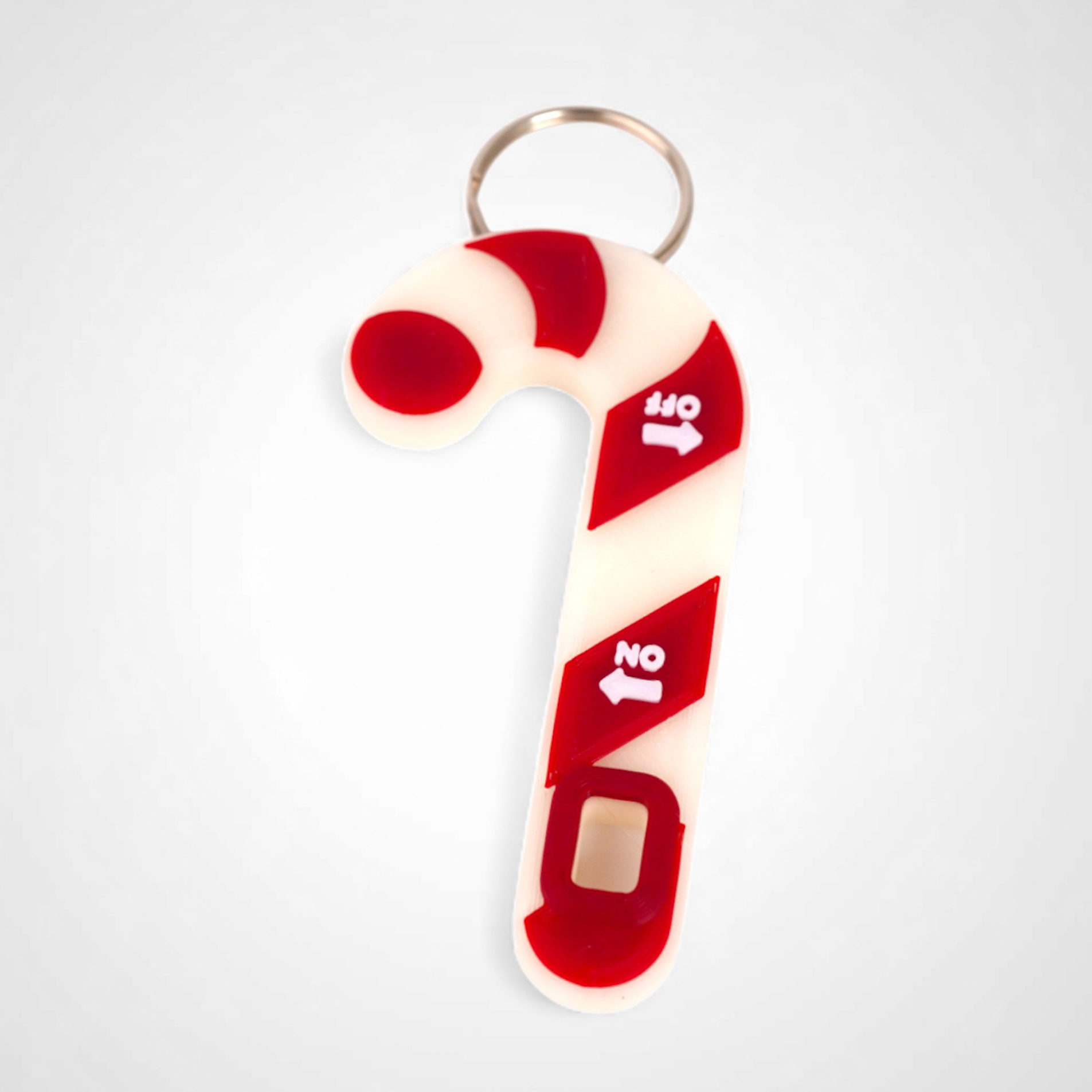 Candy cane-shaped keychain with red and white design on a light gray background