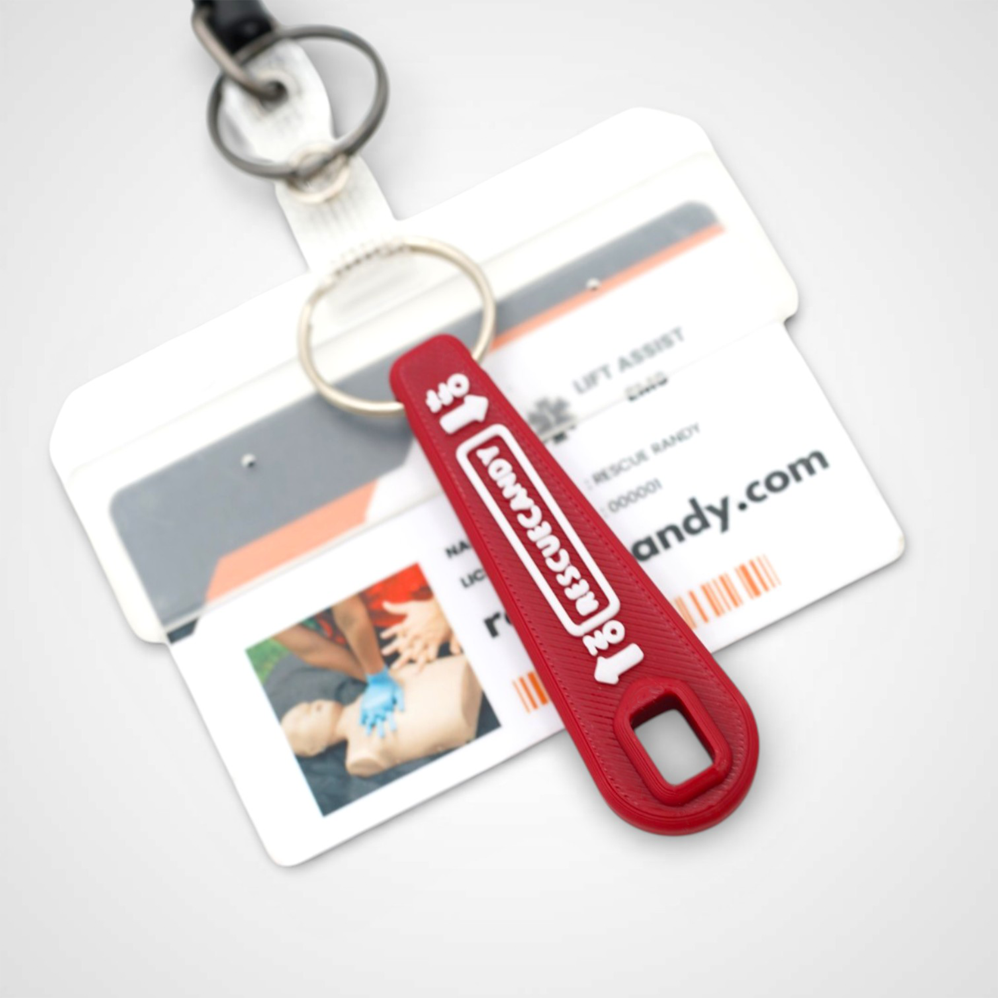 Mini red Oxygen Wrench. Made to fit CGA-870 valves. Shown attached to badge on white background.